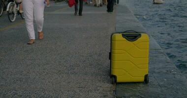 Suitcase on wheels stands on promenade video