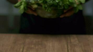 Masculin mains mettre une bol de légumes verts sur le table video