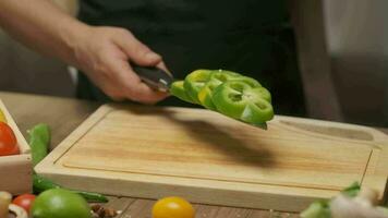 profesional cocinero prepara y cortes verde campana pimienta. cerca arriba lento movimiento video