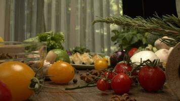 Fresh vegetables in the box on the kitchen table camera close-up. Bottles with vinegar and oil and pepper shaker mill on the back video