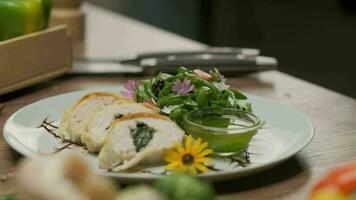 poulet rouleau avec épinard bien servi sur une assiette avec légumes verts, fleur décorations et vert pétrole video