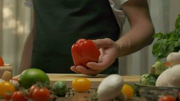 Professional chef prepares and cuts red bell pepper. Close up slow motion video