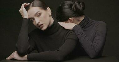 zwei jung elegant Frauen mit gut bilden auf ein schwarz Hintergrund. schleppend Bewegung, Studio Schuss. video