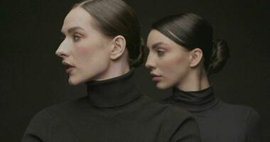 Two young elegant women with good makeup on a black background. Slow Motion, Studio shot. video