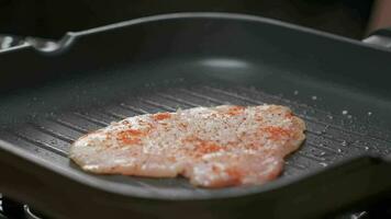 fechar acima profissional chefe de cozinha grelhar frango filé. lento movimento video