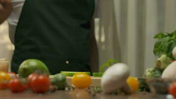 Professional chef prepares and cuts green bell pepper. Close up slow motion video