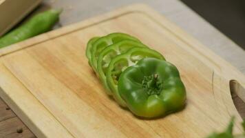 Professional chef prepares and cuts green bell pepper. Close up slow motion video