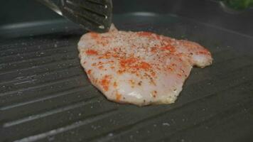 Close up professional chef grilling chicken fillet. Slow motion video