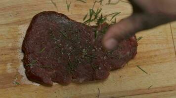 professioneel chef is van toepassing Groenen naar vlees steak. langzaam beweging dichtbij omhoog. video