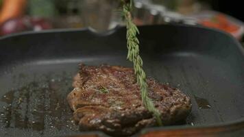 vicino su professionale capocuoco grigliate carne filetto bistecca. lento movimento video