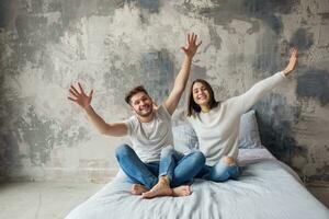 joven contento sonriente Pareja sentado en cama a hogar foto