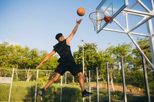 negro hombre haciendo Deportes, jugando baloncesto en amanecer, activo estilo de vida, soleado verano Mañana foto