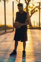 negro hombre haciendo Deportes, jugando baloncesto en amanecer, activo estilo de vida, soleado verano Mañana foto