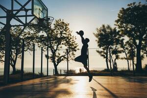 cool black man doing sports, playing basketball on sunrise, jumping silhouette photo