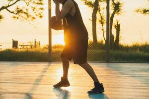 black man doing sports, playing basketball on sunrise, active lifestyle, sunny summer morning photo