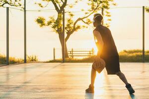 negro hombre haciendo Deportes, jugando baloncesto en amanecer, activo estilo de vida, soleado verano Mañana foto