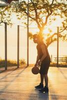 black man doing sports, playing basketball on sunrise, active lifestyle, sunny summer morning photo