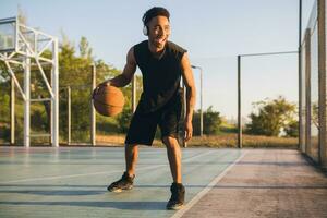 negro hombre haciendo Deportes, jugando baloncesto en amanecer, activo estilo de vida, soleado verano Mañana foto