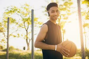 black man doing sports, playing basketball on sunrise, active lifestyle, sunny summer morning photo