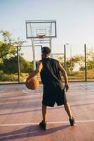 black man doing sports, playing basketball on sunrise, active lifestyle, sunny summer morning photo