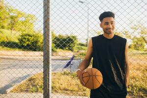 black man doing sports, playing basketball on sunrise, active lifestyle, sunny summer morning photo