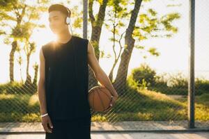 negro hombre haciendo Deportes, jugando baloncesto en amanecer, activo estilo de vida, soleado verano Mañana foto