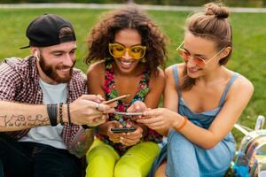 happy young company of talking smiling friends sitting park photo