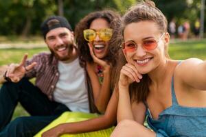 happy young company of friends sitting park photo