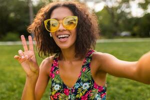 joven elegante negro mujer teniendo divertido en parque verano Moda estilo foto