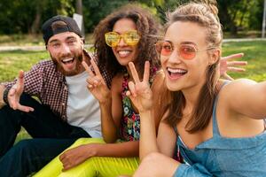 happy young company of friends sitting park photo