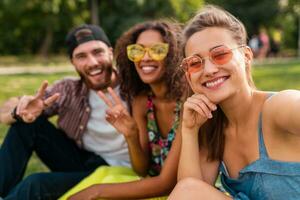 happy young company of friends sitting park photo