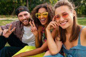 happy young company of friends sitting park photo