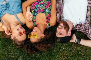 happy young company of friends sitting park photo