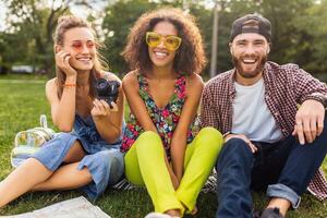 happy young company of friends sitting park photo