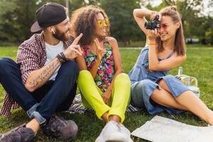 happy young company of friends sitting park photo