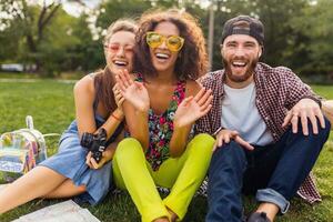 happy young company of friends sitting park photo