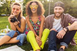 happy young company of friends sitting park photo