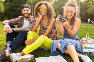 happy young company of friends sitting park photo