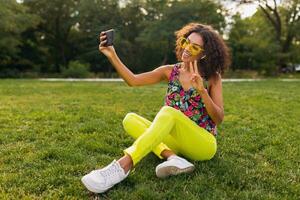 young stylish black woman having fun in park summer fashion style photo