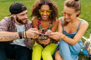 happy young company of friends sitting park photo