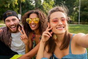 happy young company of friends sitting park photo