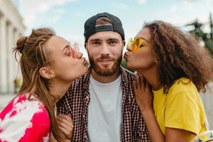 two women kissing man, happy excited emotion, young company of smiling friends photo