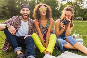 happy young company of friends sitting park photo