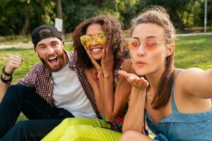 happy young company of friends sitting park photo