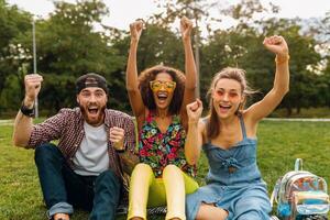 happy young company of friends sitting park photo