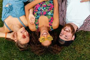 happy young company of friends sitting park photo