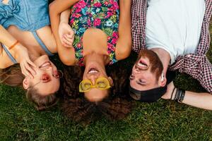 happy young company of friends sitting park photo