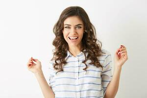 close up portrait young pretty woman smilingl face expression, holding hands up, success, winner, dressed in shirt isolated, happy, positive mood, sincere smile, long curly hair, white teeth photo