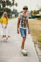 joven elegante hipster Pareja en amor en vacaciones con perro y patineta foto