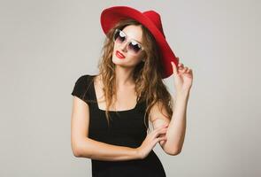 young beautiful stylish woman in black dress, red hat photo